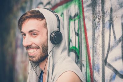 young hipster gay man listening music headphones