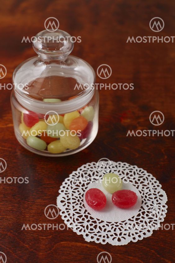 Coloured sugar candies in a glass can on a wooden table