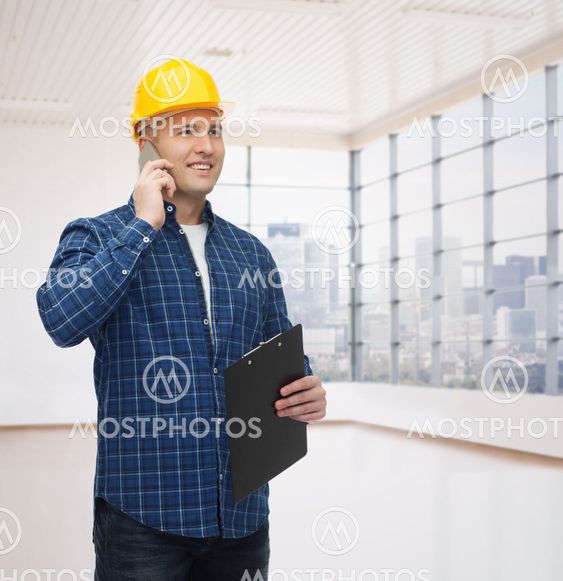 smiling male builder in helmet with clipboard