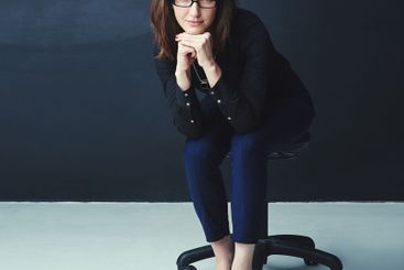 Portrait, confidence and businesswoman on chair in...