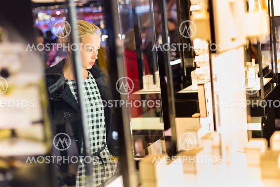 Beautiful woman standing in front of showcase.