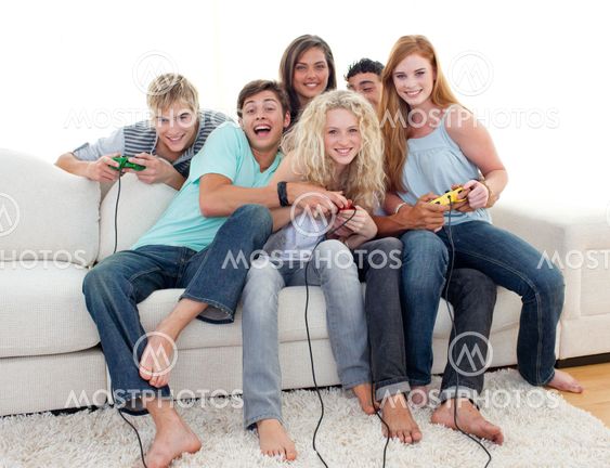 Teenagers playing video games at home