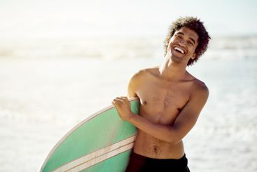 Surfing, portrait and man laughing at beach, sea and...