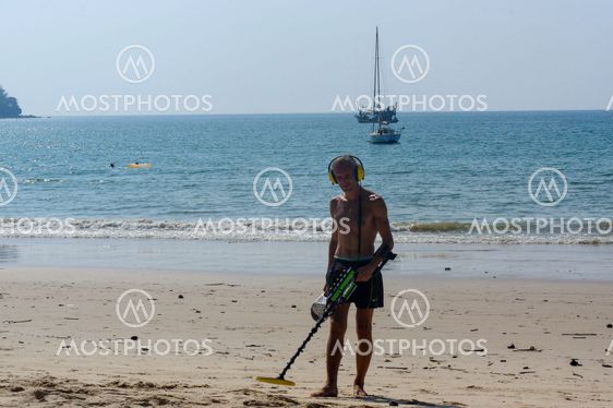 Treasure hunter with Metal detector on the beach