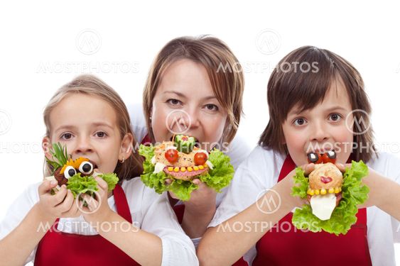 Woman and kids taking a bite from creative sandwiches