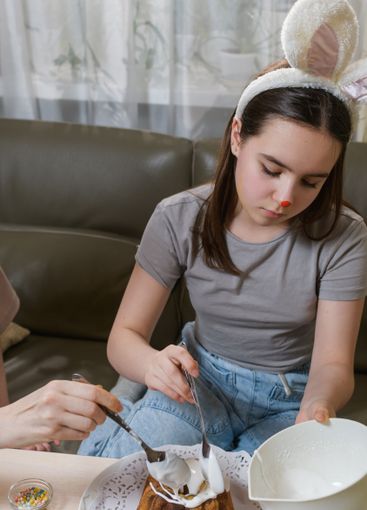 Decorating an Easter cake with white icing.