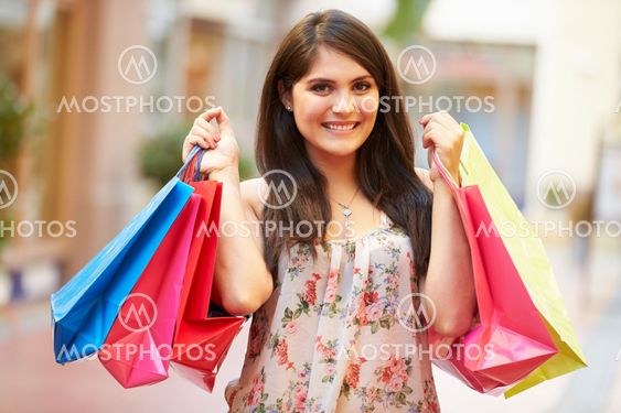 Woman Walking Through Mall Carrying Shopping Bags