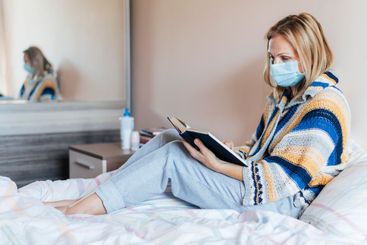 woman with book medical mask quarantine