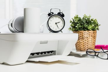 Home office workspace featuring a printer, clock, and...