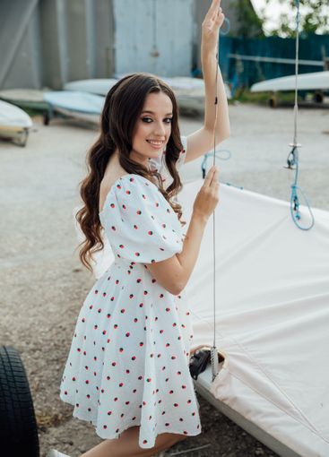 Beautiful brunette woman in summer dress by the boat in...