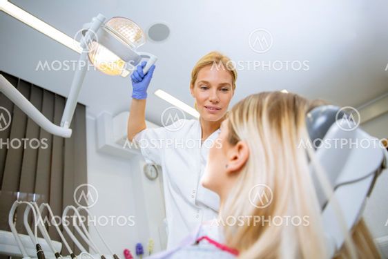 Female doctor in uniform checking up female patient's...