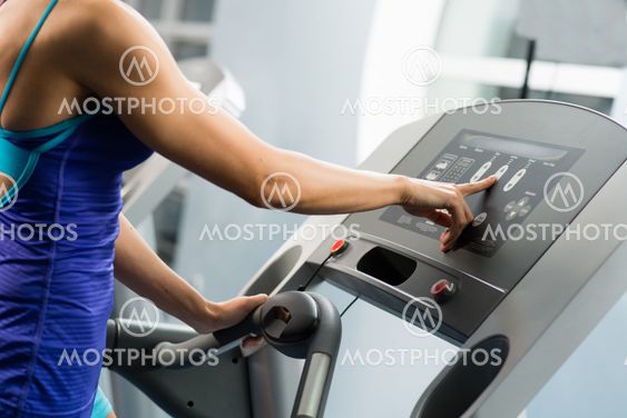 woman adjusts the treadmill