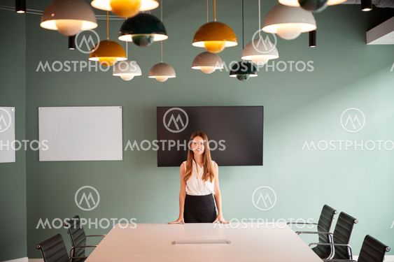 Portrait Of Young Businesswoman Standing By Boardroom...