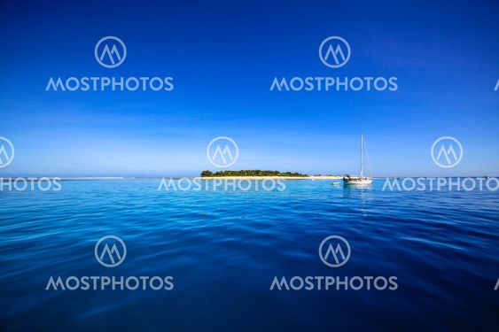 Boat and beautiful Fiji atoll island with white beach