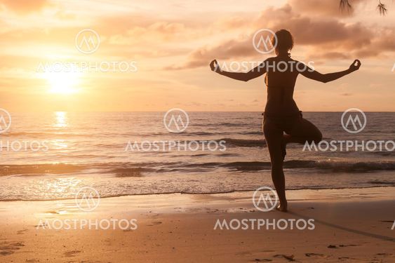 Yoga girl silhouette on beautiful sunset on the sea.