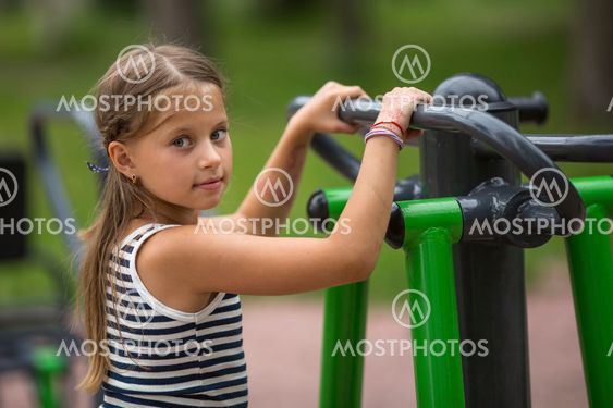 Portrait of little girl doing warm-up on the Playground.