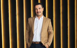 Business executive stands confidently against a modern...