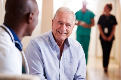 Doctor Welcoming To Senior Male Patient Being Admitted...