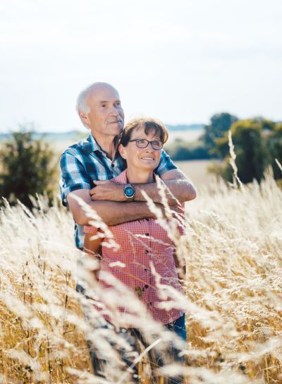 Senior man cuddling with his wife in the grass