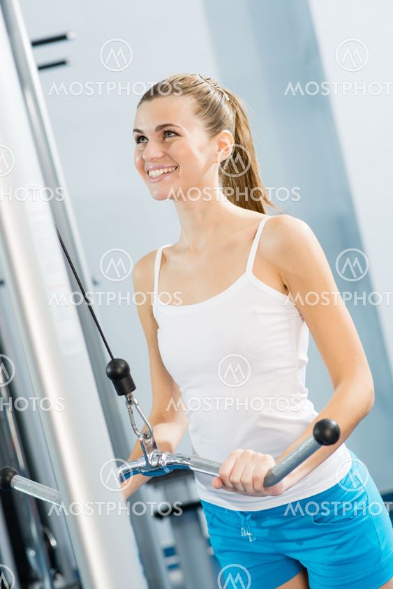 young woman doing body-building in the Gym