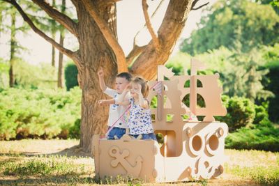 Boy and girl playing in a cardboard boat