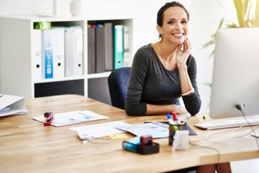Businesswoman, happy and portrait at desk in office for...