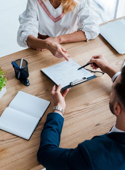 overhead view of blonde employee pointing with finger at...