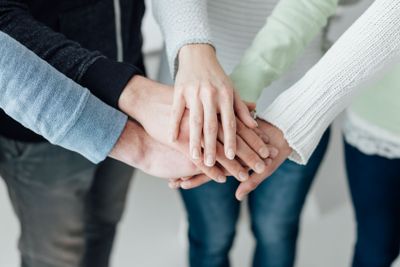 Young people stacking hands