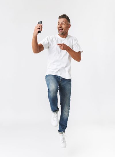 Full length image of brunette man 30s wearing casual...