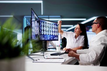 Doctors In Clinic Looking At Brain MRI Scan
