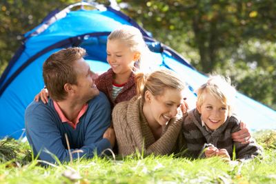 Young family poses outside of tent