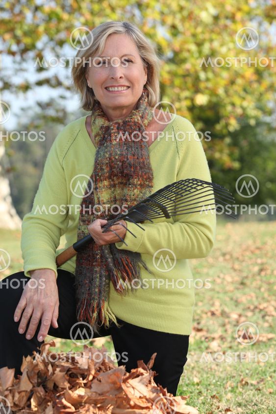 Woman raking leaves in a yard