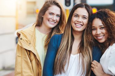 Women, laughing and hug in urban portrait, holiday...