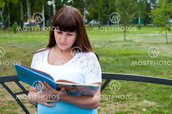Portrait of nice young smiling woman with book