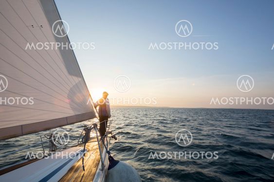 Man Standing On Front Of Luxury Yacht In Sea