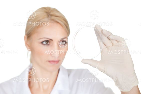 Researcher looking into empty petri dish