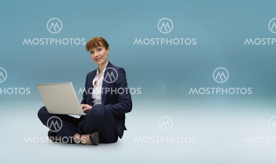 Composite image of businesswoman using laptop