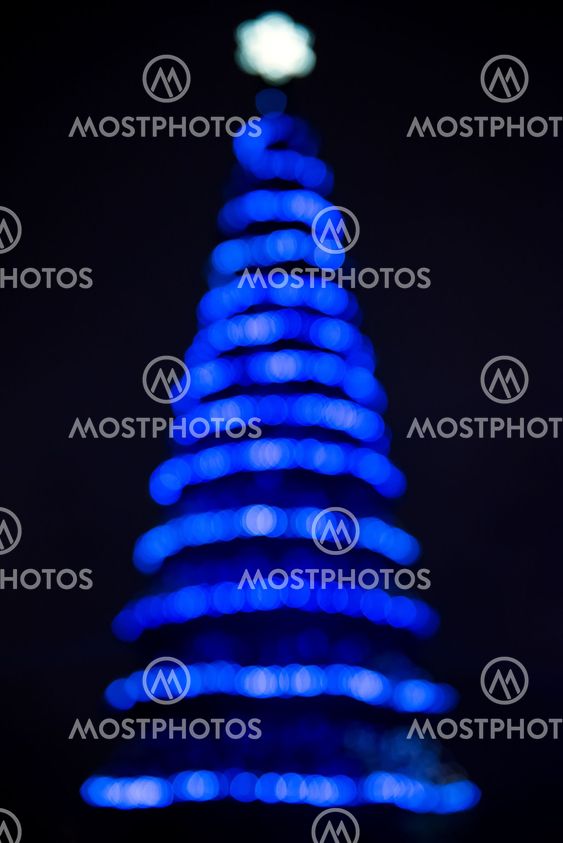 Defocused christmas tree silhouette with blue lights
