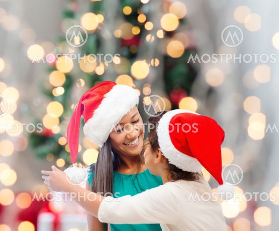 happy mother and girl in santa hats
