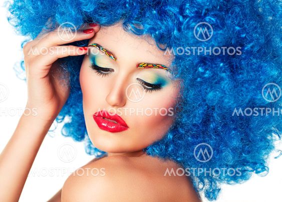Portrait of a young beautiful girl with bright makeup in blue wig