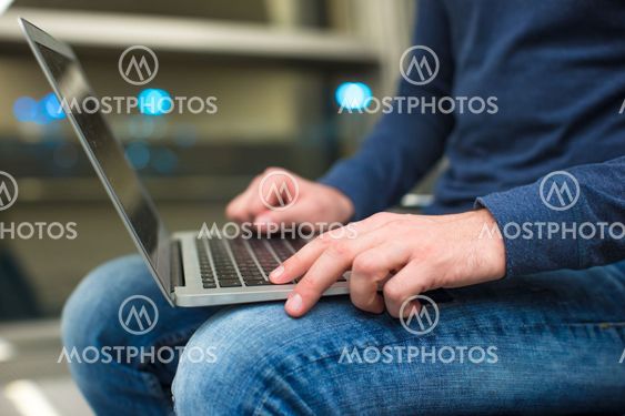 Businessman using laptop or notebook computer while sitting on the chair at the airport