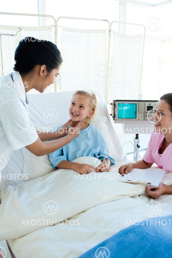 Female doctor checking blond girl's throat