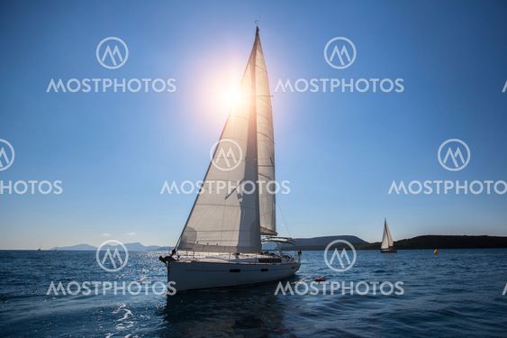 Luxury sailing ship yachts boat with white sails in the Sea.