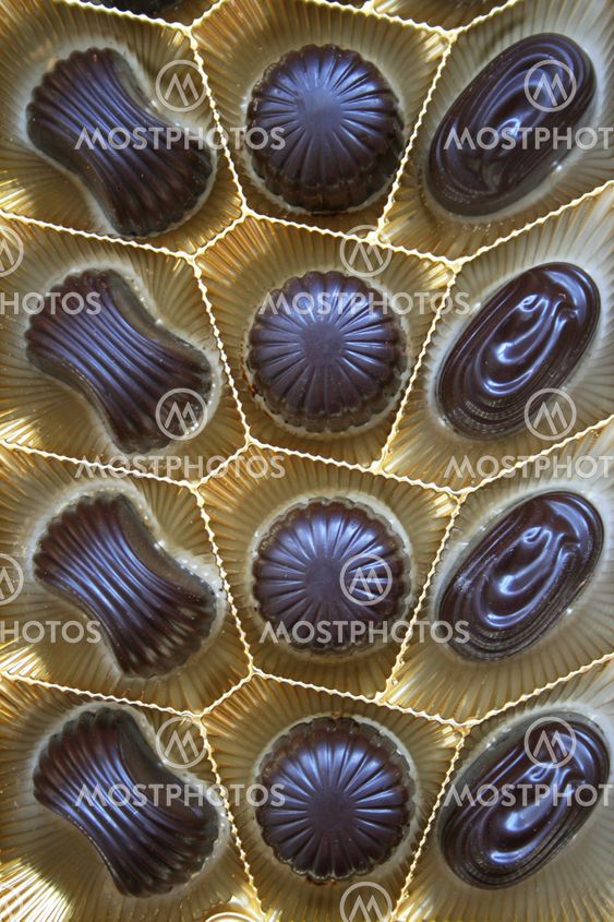 Delicious dark chocolate sweets in box as background