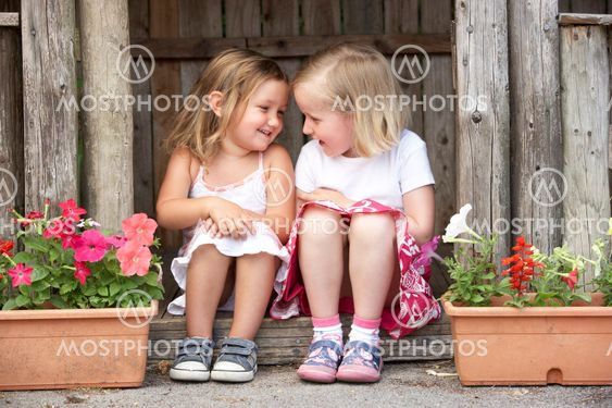 Two Young Girls Playing in Wooden House