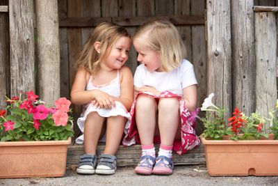 Two Young Girls Playing in Wooden House