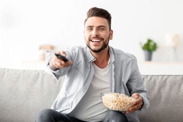 Domestic pastime. Cheerful man resting on couch...