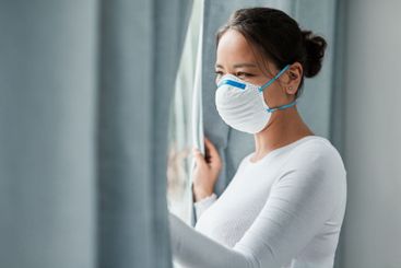 Woman, mask and window for covid, quarantine and health...