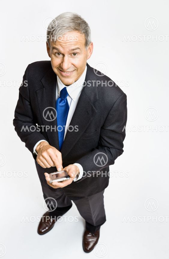 Businessman text messaging on cell phone