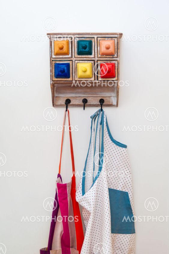 Kitchen aprons on colourful hanger with little drawers.